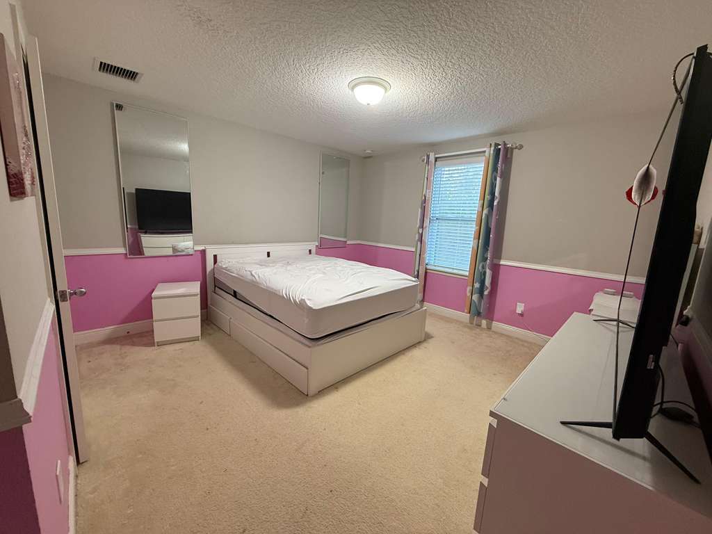 Bedroom before renovation with carpet